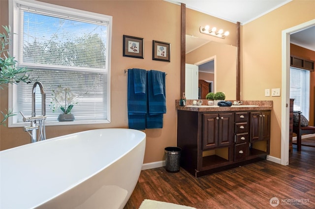 bathroom featuring hardwood / wood-style flooring, a tub to relax in, and vanity