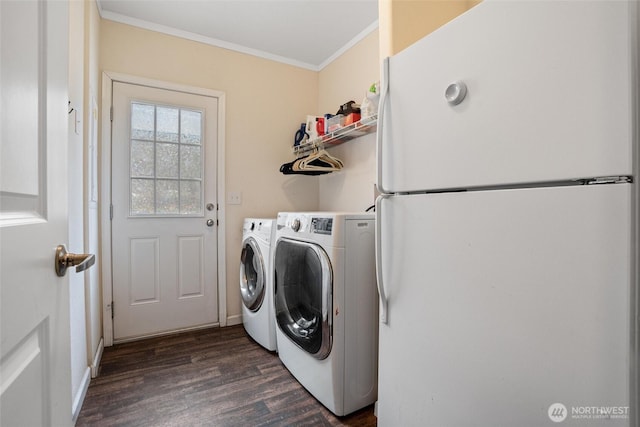 laundry room with crown molding, washing machine and clothes dryer, and dark hardwood / wood-style floors