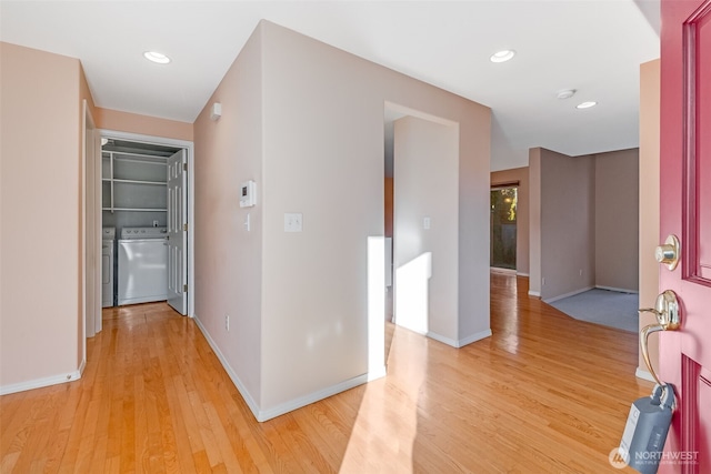 hallway with washing machine and dryer and light hardwood / wood-style floors