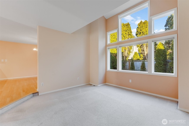 empty room with a towering ceiling and light carpet