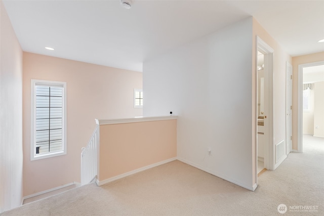 hallway featuring light colored carpet