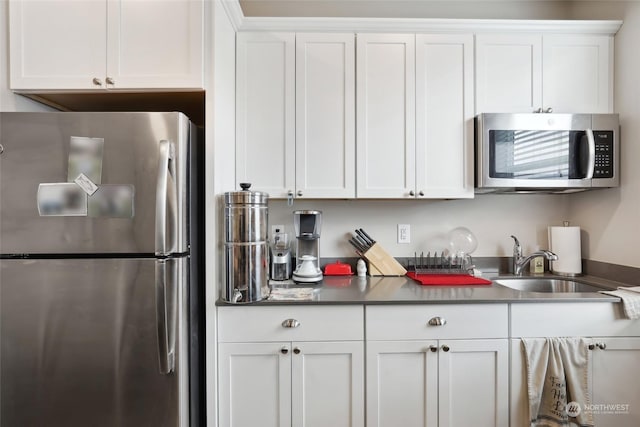 kitchen with white cabinetry, stainless steel appliances, and sink