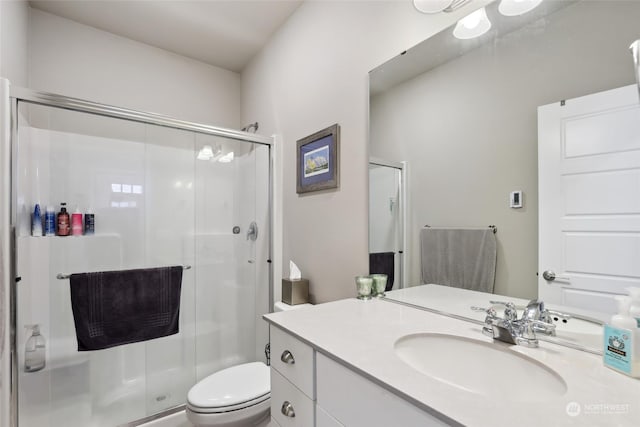 bathroom with walk in shower, vanity, and toilet