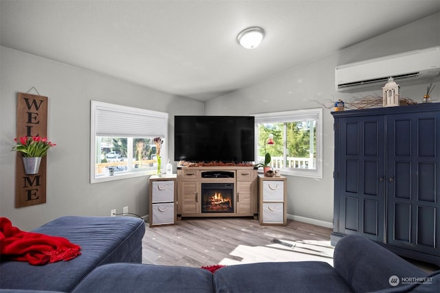 living room with lofted ceiling, a healthy amount of sunlight, a wall unit AC, and light wood-type flooring