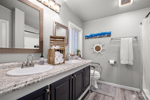 bathroom with vanity, hardwood / wood-style floors, ornamental molding, and toilet