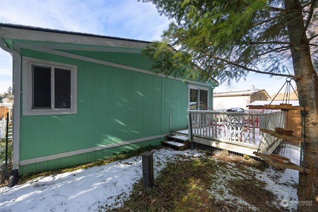 view of snowy exterior featuring a deck