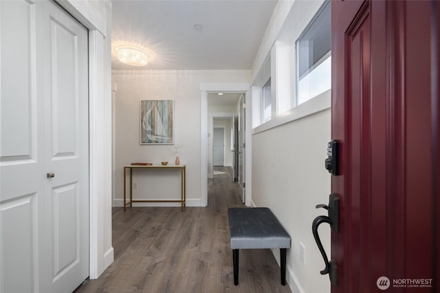 corridor with baseboards and wood finished floors