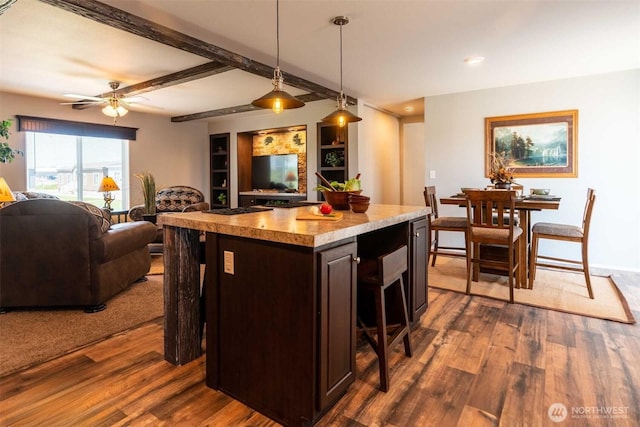 kitchen featuring pendant lighting, a kitchen island, a kitchen breakfast bar, dark hardwood / wood-style floors, and dark brown cabinetry