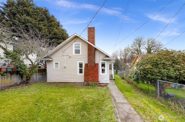 rear view of house featuring a yard