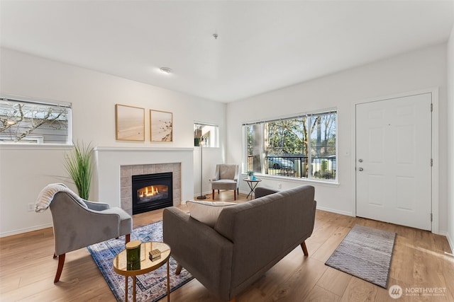 living room featuring a tile fireplace and light hardwood / wood-style floors