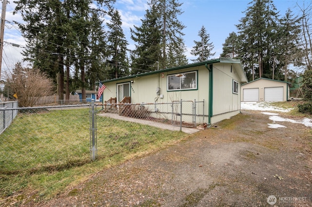 view of front of house featuring a garage, an outdoor structure, and a front lawn