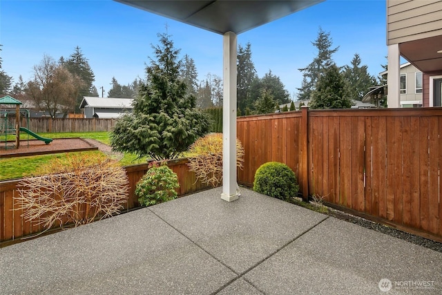 view of patio featuring a fenced backyard and a playground