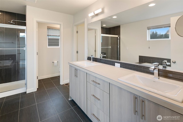 bathroom with a stall shower, a sink, toilet, and tile patterned floors