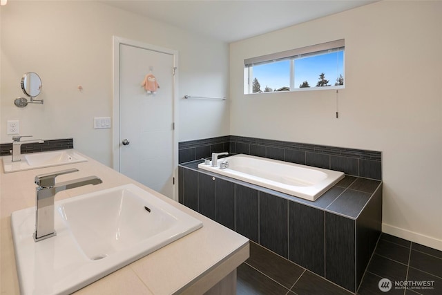 bathroom with tile patterned flooring, a sink, and a bath