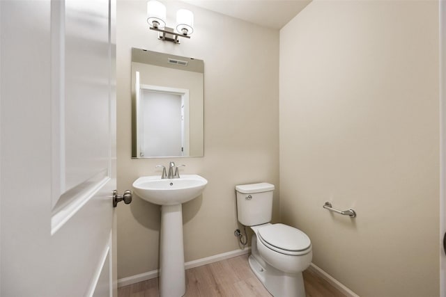 bathroom featuring sink, hardwood / wood-style floors, and toilet