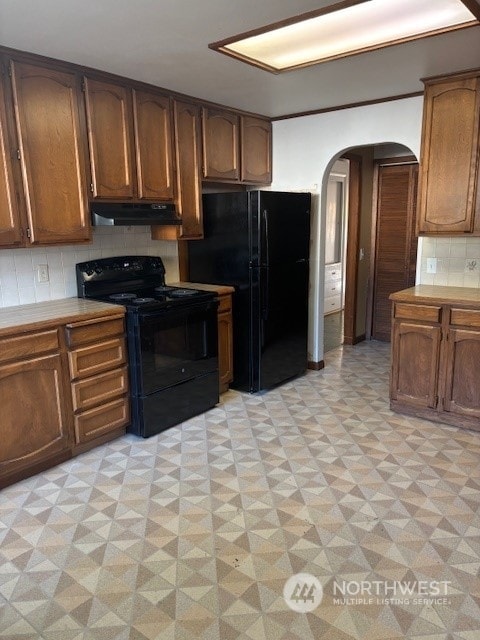 kitchen featuring tasteful backsplash and black appliances