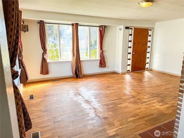 entrance foyer with visible vents, baseboards, and wood finished floors