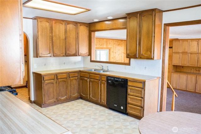 kitchen featuring brown cabinets, light floors, backsplash, a sink, and dishwasher