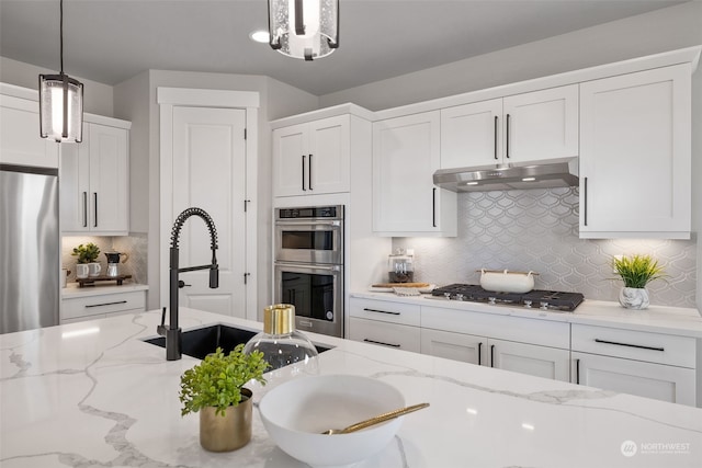 kitchen with stainless steel appliances, pendant lighting, and white cabinets