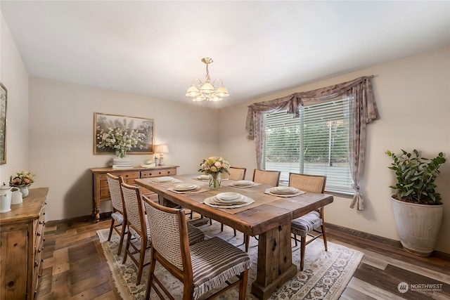 dining room with dark hardwood / wood-style floors and a chandelier