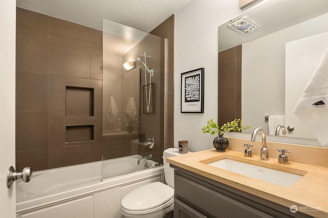 full bathroom with tiled shower / bath combo, vanity, and toilet