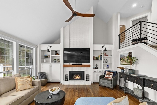 living room with ceiling fan, high vaulted ceiling, dark wood-type flooring, and a fireplace