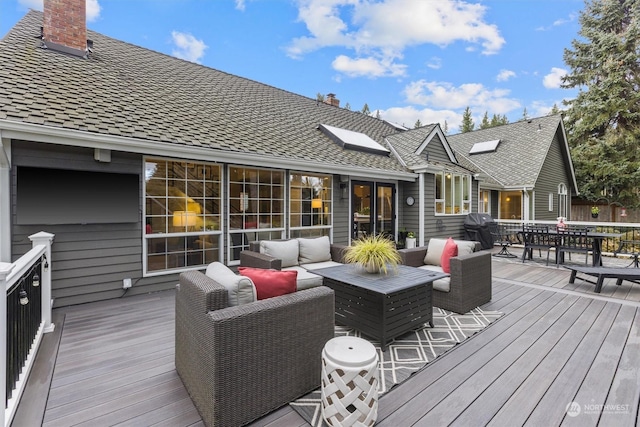 wooden terrace with a grill and an outdoor hangout area