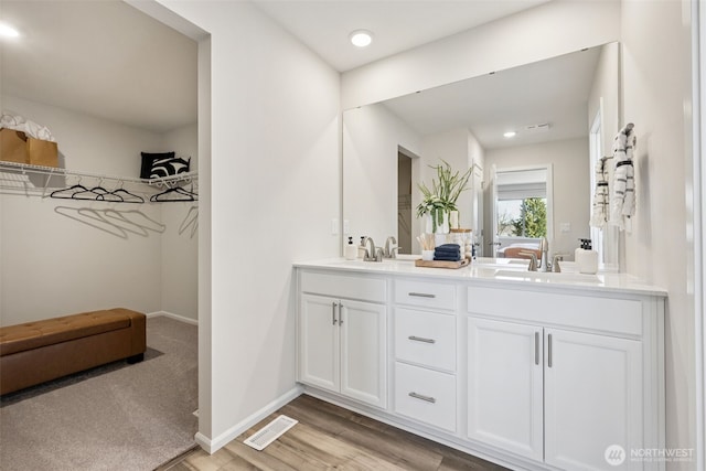 287 Wind River Ct, Chehalis, WA 98532 - bathroom featuring double vanity, baseboards, visible vents, wood finished floors, and a sink