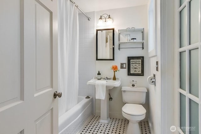 full bath featuring shower / bath combo, baseboards, and toilet