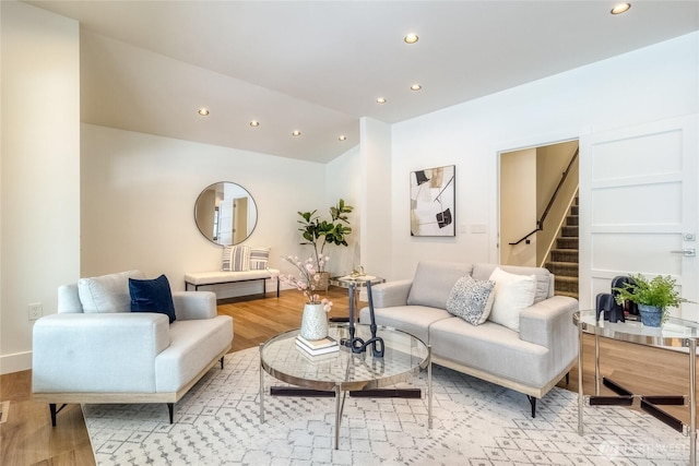 living room featuring light wood finished floors, stairs, vaulted ceiling, and recessed lighting