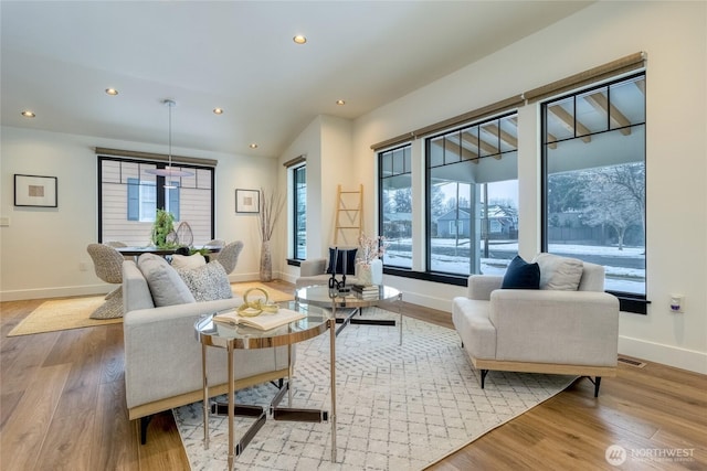 living area with light wood-style flooring, baseboards, and recessed lighting