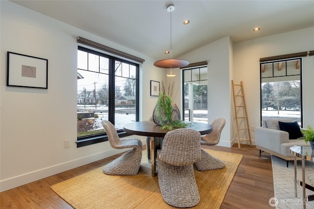 dining area featuring lofted ceiling, baseboards, wood finished floors, and recessed lighting