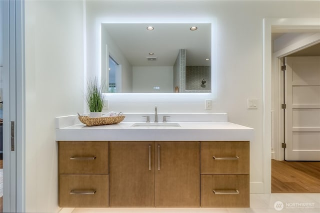 bathroom featuring recessed lighting, wood finished floors, and vanity