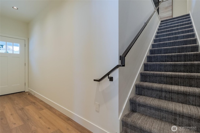 staircase featuring recessed lighting, baseboards, and wood finished floors