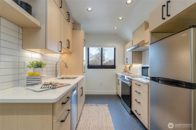 kitchen featuring light brown cabinets, appliances with stainless steel finishes, a sink, and baseboards