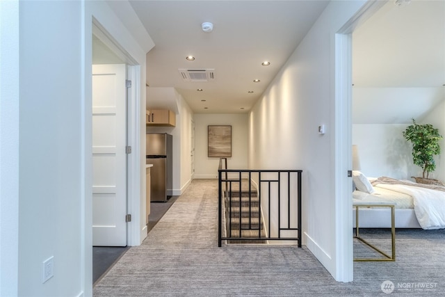 corridor featuring carpet floors, recessed lighting, visible vents, an upstairs landing, and baseboards