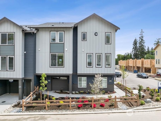 view of front of house featuring driveway, a fenced front yard, and board and batten siding