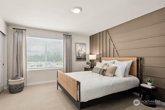 bedroom featuring light carpet and baseboards