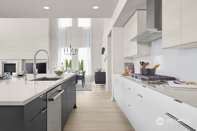 kitchen featuring wall chimney exhaust hood, sink, decorative light fixtures, stainless steel appliances, and light hardwood / wood-style floors