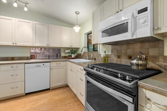 kitchen featuring sink, decorative light fixtures, vaulted ceiling, white appliances, and white cabinets