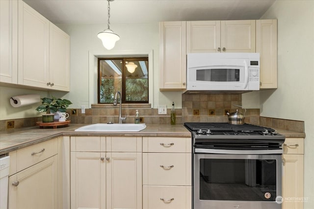 kitchen with pendant lighting, sink, white appliances, and tasteful backsplash