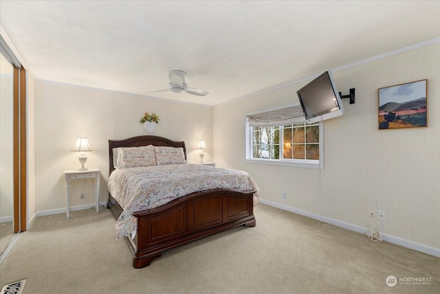 bedroom featuring ornamental molding, light carpet, and ceiling fan