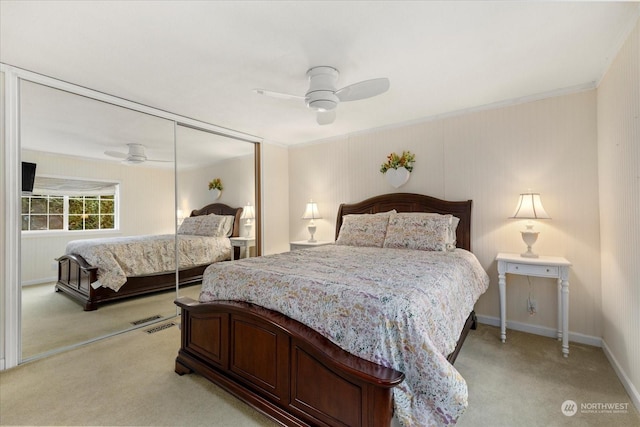 carpeted bedroom featuring ornamental molding, ceiling fan, and a closet