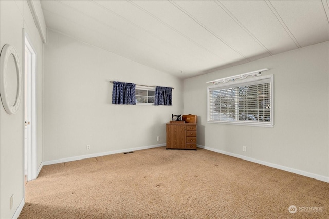 unfurnished bedroom with vaulted ceiling and carpet floors