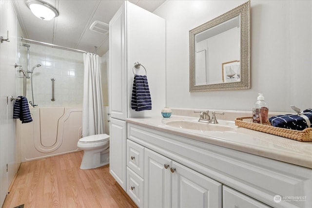 full bathroom with hardwood / wood-style flooring, vanity, shower / bathtub combination with curtain, and toilet