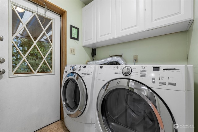 washroom with cabinets and washing machine and clothes dryer