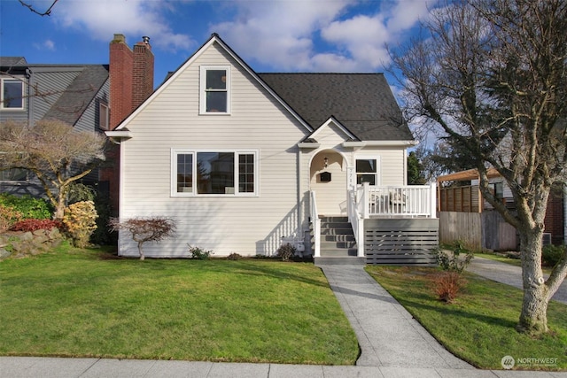 view of front of house with a wooden deck and a front lawn