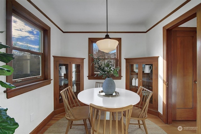 dining room with crown molding and wood-type flooring