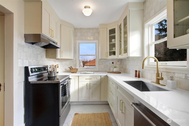 kitchen featuring sink, light tile patterned floors, stainless steel appliances, decorative backsplash, and white cabinets