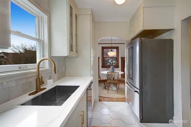 kitchen featuring light tile patterned flooring, sink, white cabinetry, hanging light fixtures, and appliances with stainless steel finishes